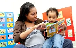 a person reading a book to a child