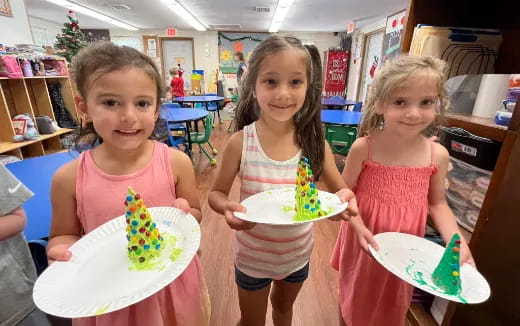 a group of girls holding plates of cake