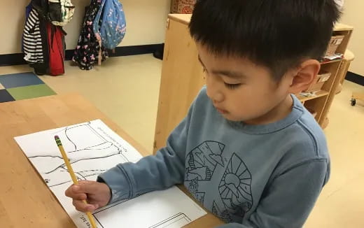 a young boy drawing on a paper