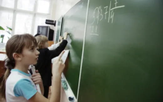 a teacher writing on a chalkboard