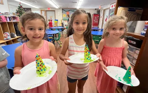 a group of girls holding plates of cake