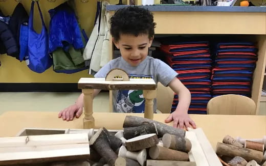 a boy holding a wooden toy