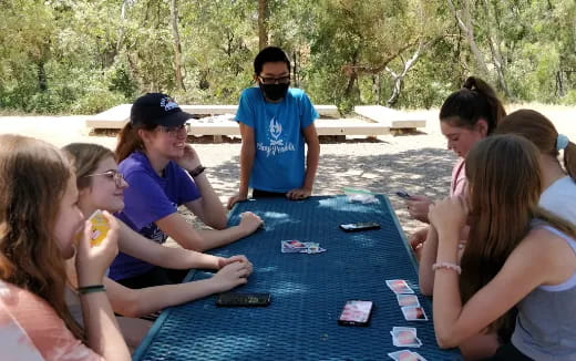 a group of people sitting around a table outside