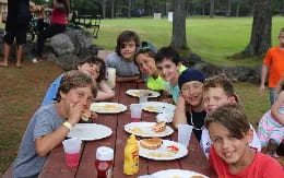 a group of people sitting at a table eating food