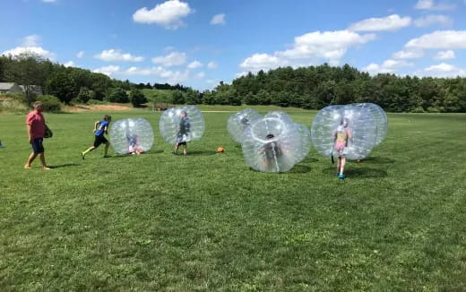 a group of people playing with bubbles in a field