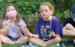 a group of children sitting on the ground with paint on their faces