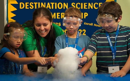 a group of people wearing safety goggles around a globe