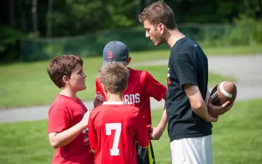 a man talking to a group of boys