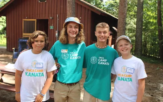 a group of people posing for a photo in front of a cabin