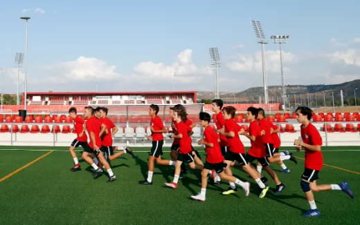 a group of people in red uniforms running on a field