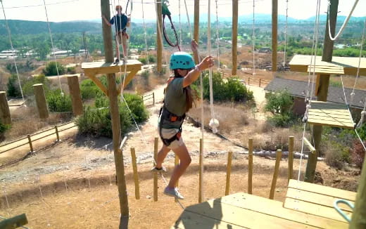 a person wearing a helmet and climbing a wooden structure