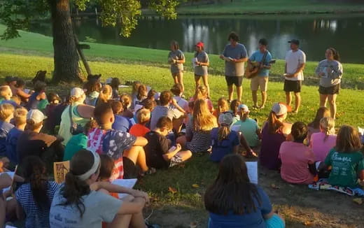 a group of people sitting on the grass