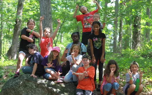 a group of people posing for a photo in the woods