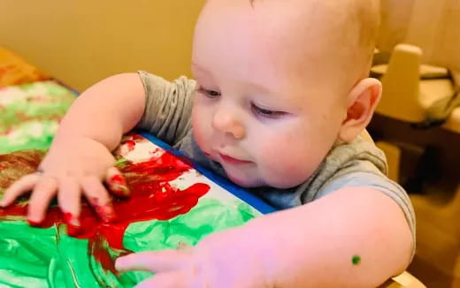 a baby eating a red bowl