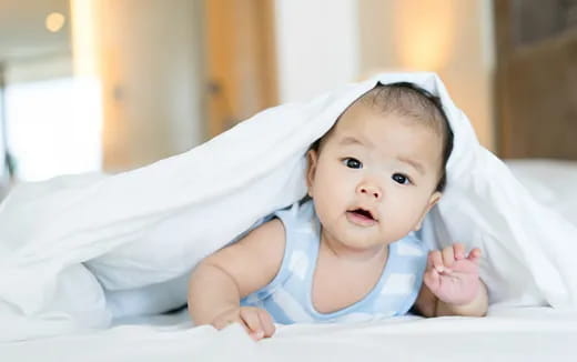 a baby lying on a white surface