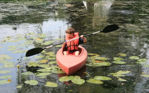 a boy in a pink kayak