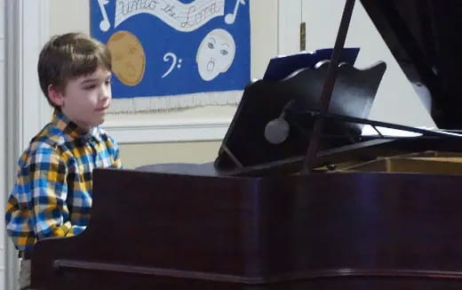 a boy playing a piano