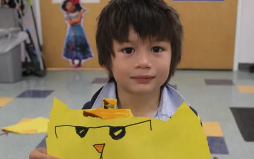 a child holding a yellow and black object