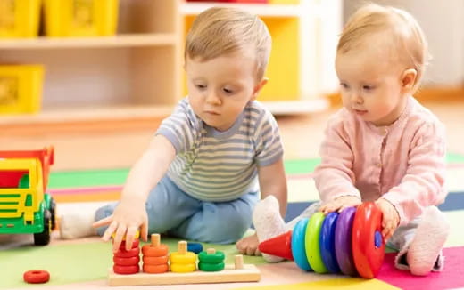 a couple of babies playing with toys