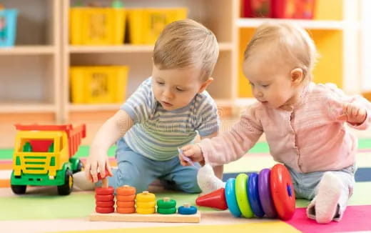 a couple of babies playing with toys