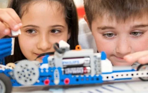 a couple of kids looking at a toy