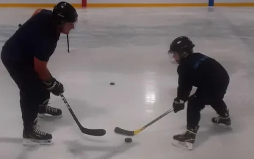 a couple of people playing hockey