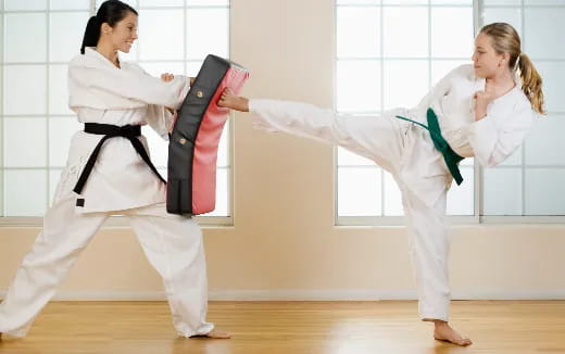 a couple of women in karate uniforms