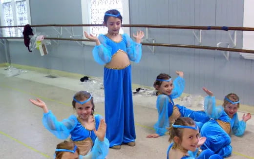 a group of children in blue leotards in a gym