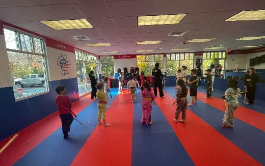 a group of children playing in a room with a red carpet