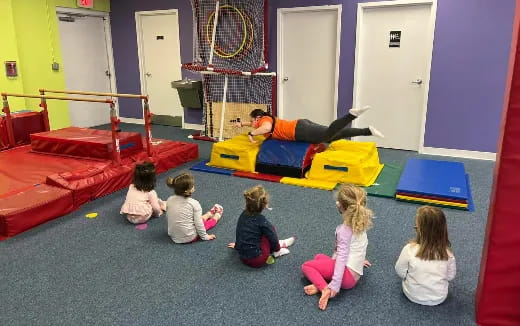 a group of children playing on a mat in a room