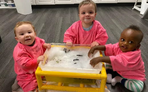 a group of children playing with a yellow bucket