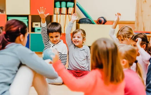 a group of children raising their hands