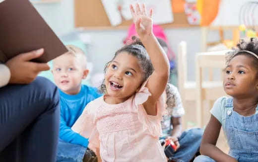 a group of children raising their hands