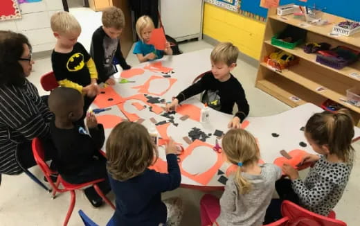 a group of children sitting around a table