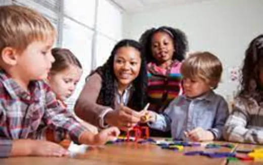 a group of children sitting at a table playing a board game