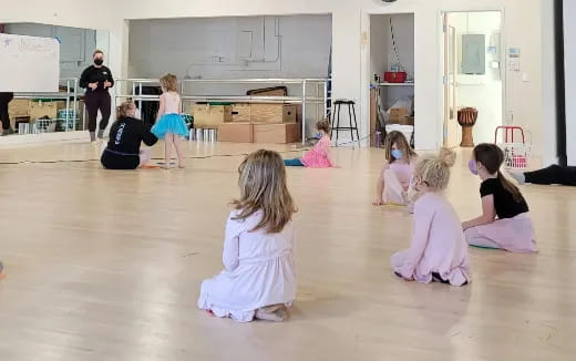 a group of children sitting on the floor in a room