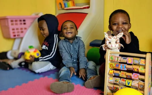 a group of children sitting on the floor with toys