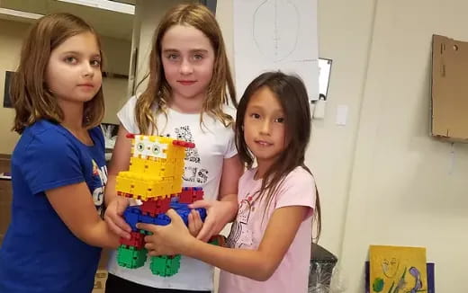 a group of girls holding a toy