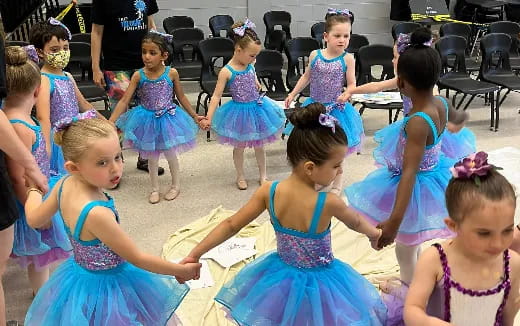 a group of girls in dresses dancing