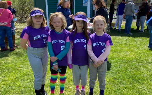 a group of girls in matching purple shirts