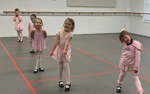 a group of girls wearing pink dresses and roller blades