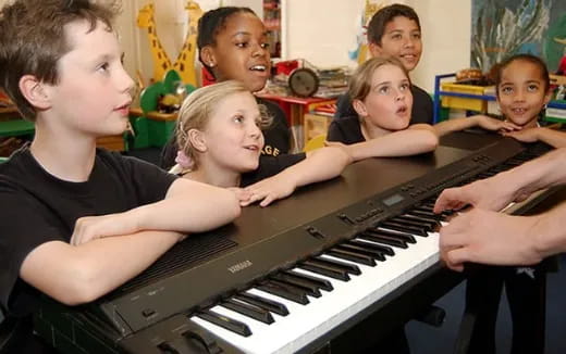 a group of kids playing a piano