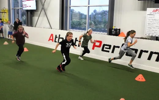a group of people running on a green mat
