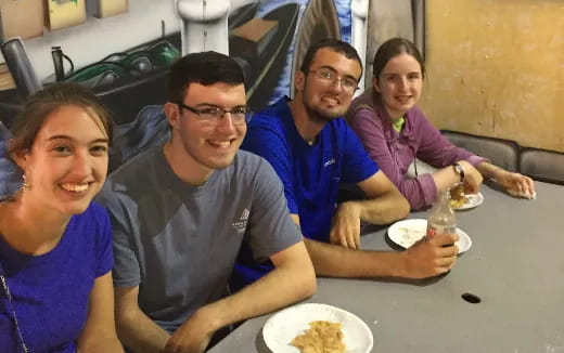 a group of people sitting at a table eating food