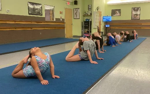 a group of people sitting on the floor in a gym