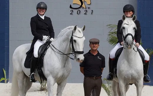 a group of people standing next to a white horse