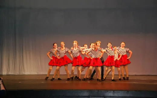 a group of women in red dresses