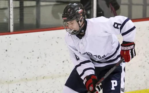 a hockey player in a white uniform