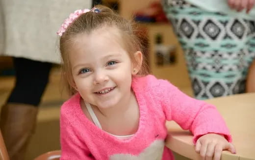 a little girl wearing a pink dress