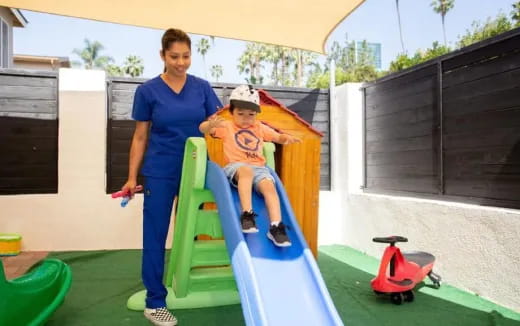 a man and a boy on a playground slide